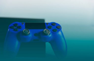 Işık arkaplanındaki kontroller ve oyun konsolu. Elektronik oyun aksesuarları. Video oyunu oyun platformu. Oyuncular için dilek öğesi. Modern, kablosuz oyun ve yön denetimi.