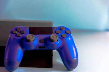 Işık arkaplanındaki kontroller ve oyun konsolu. Elektronik oyun aksesuarları. Video oyunu oyun platformu. Oyuncular için dilek öğesi. Modern, kablosuz oyun ve yön denetimi.