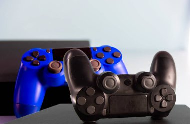 Işık arkaplanındaki kontroller ve oyun konsolu. Elektronik oyun aksesuarları. Video oyunu oyun platformu. Oyuncular için dilek öğesi. Modern, kablosuz oyun ve yön denetimi.