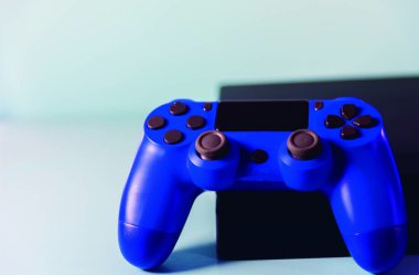 Işık arkaplanındaki kontroller ve oyun konsolu. Elektronik oyun aksesuarları. Video oyunu oyun platformu. Oyuncular için dilek öğesi. Modern, kablosuz oyun ve yön denetimi.