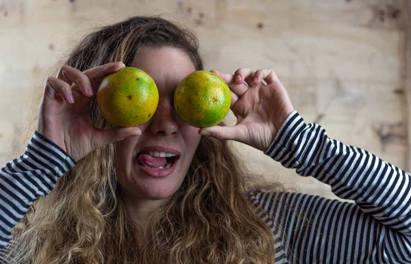 Facial expression of Brazilian woman with orange fruits. Brazilian blonde girl portrait. Face of beautiful young woman. Girl posing for photo shoot doing facial interjections.