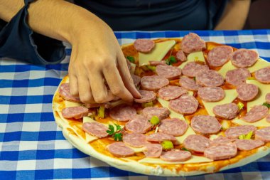 Kadın elleri ev yapımı peynirli ve pepperonili pizza hazırlıyor. Tipik İtalyan yemekleri. Yemek pişirmek. Ev yapımı tatlar. Atıştırmalık Kırmızı sos. Brezilya mutfağının tipik lezzeti.