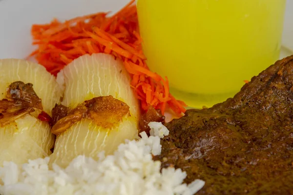 Brazilian food dish with steak and rice and carrots and cassava with an eye. Executive lunch. Homemade and seasoned food. Roast beef with sauce and salads. Homemade delights. Typical dish of Brazil.