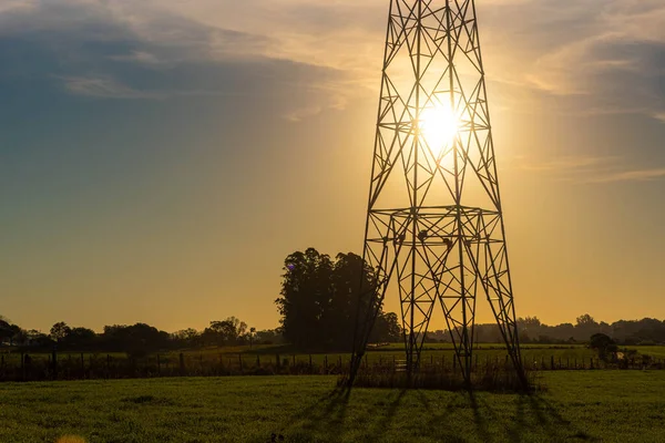電力塔と日没 送電塔だ 農業地域 夕暮れ時の田園風景 エネルギー流通インフラ — ストック写真