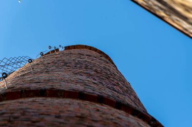 Terk edilmiş eski fabrikanın tuğla kulesi. Antik mimari. Terk edilmiş tahıl, kooperatif fabrikası alıyor. Gıda işleme endüstrisi.