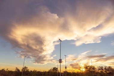 Braz 'da bir alışveriş merkezinin otoparkında dramatik bir gökyüzü ve gün batımı silueti.