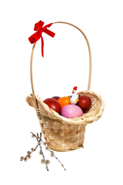 Easter eggs and willow in a wicker basket — Stock Photo, Image