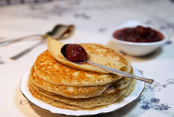 Pancakes on a plate and a spoon with strawberry jam — Stock Photo, Image