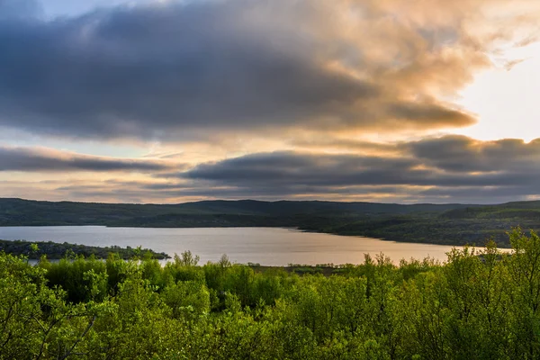 Nuvens de tempestade ao pôr do sol sobre a floresta e o lago — Fotografia de Stock
