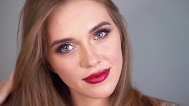 Kvinna med professionell makeup, röda läppar och sotade ögon poserar — Stockvideo