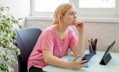 Akıllı telefon ve tablet kullanan güzel bir kadın. Evden çalışıyorum. İnternetten alışveriş