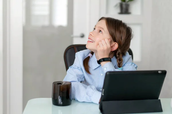 Niña aprender por tableta en casa. Enseñanza a distancia en cuarentena. Aislamiento —  Fotos de Stock