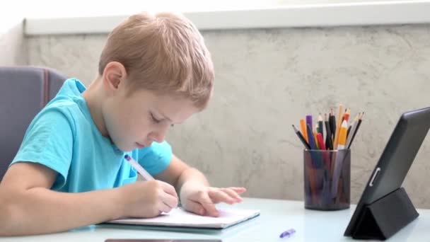 Niño aprender por tableta en casa. Enseñanza a distancia en cuarentena. Aislamiento. Tareas — Vídeos de Stock