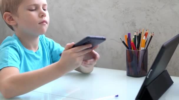 Niño jugando con el teléfono inteligente en casa. Cuarentena — Vídeos de Stock