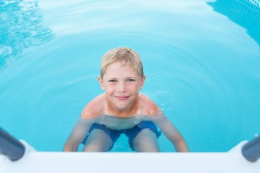 Havuzdaki küçük komik çocuk.