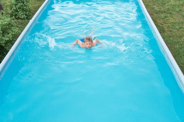 Havuzdaki küçük komik çocuk.