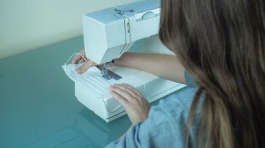 Salgını önlemek için virüs maskeleri dikiyorum.