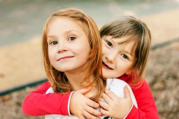 Portrait of two adorable little girls on playground — Stock Photo, Image