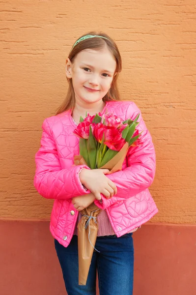 Petite fille avec des tulipes, veste rose vif — Photo