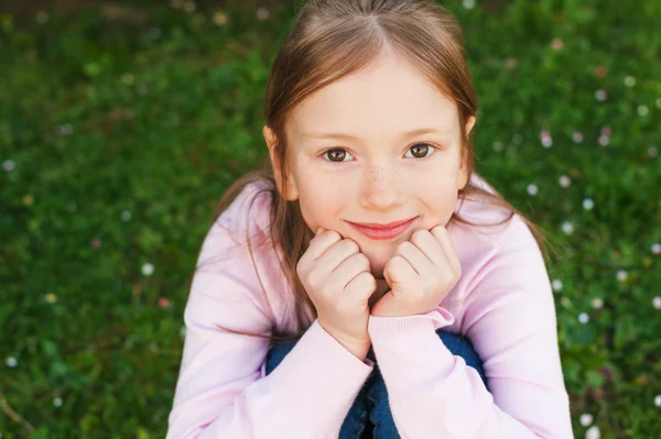Primer plano retrato de adorable niña de 6-7 años, sentada en el suelo —  Fotos de Stock