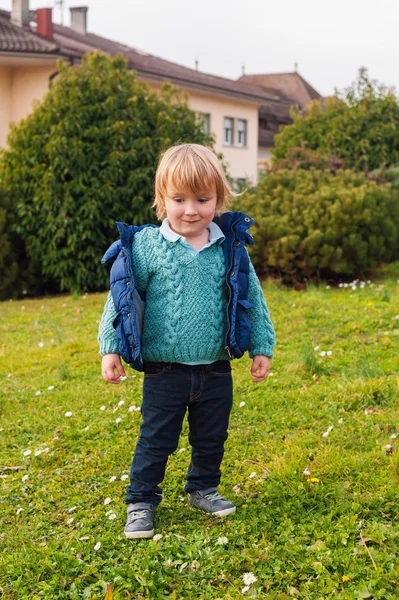 Outdoor vertical portrait of a cute little toddler boy, wearing warm knitted pullover and black denim jeans — Stock Photo, Image