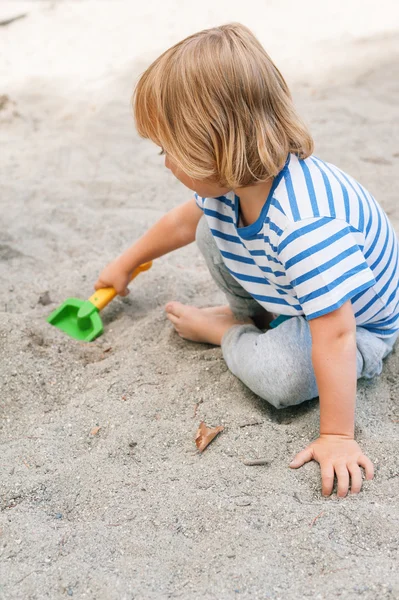 Хлопчик Тоддлер грає в пісочниці — стокове фото