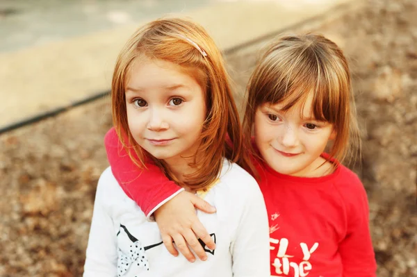 Retrato de duas meninas adoráveis no parque infantil — Fotografia de Stock