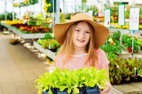 Gyerek lány vásárol kert közepén zöldségfélék palántanevelésében — Stock Fotó