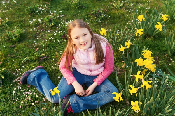 Весенний портрет милой маленькой девочки 8-9 лет, развлекающейся на открытом воздухе, играющей с цветами — стоковое фото