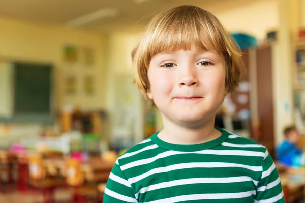 Innenporträt eines niedlichen kleinen Jungen in einem Klassenzimmer — Stockfoto
