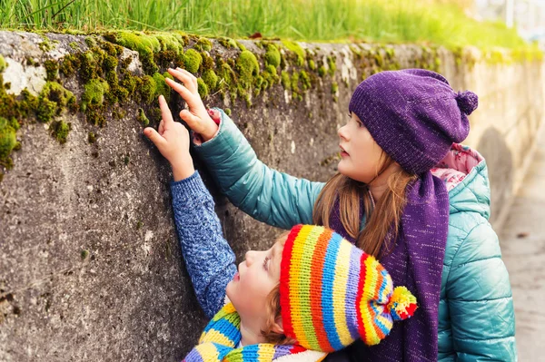 Due bambini carini che giocano all'aperto, bambina e suo fratello che passano del tempo insieme, indossando caldi cappelli colorati — Foto Stock