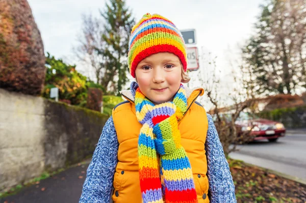 可爱的蹒跚学步的男孩穿着色彩鲜艳的帽子和围巾的室外肖像 — 图库照片