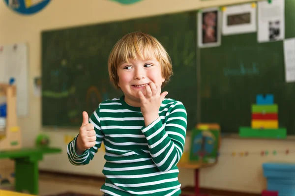 Retrato interno de um menino bonito em uma sala de aula — Fotografia de Stock