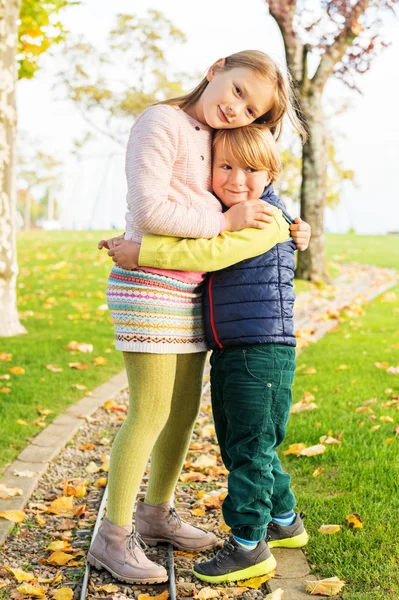 两个可爱的孩子们在美好的秋天一天在公园里玩 — 图库照片