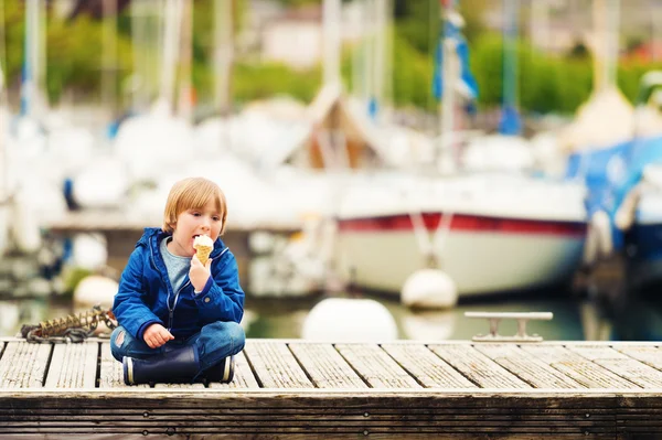 Cute little boy eating ice cream by the lake — Stock Photo, Image