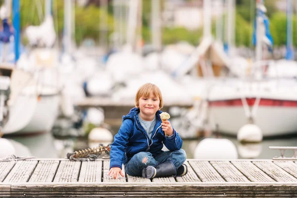 Bonito menino comendo sorvete junto ao lago — Fotografia de Stock