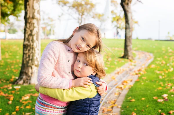 Два очаровательных ребенка играют в парке в хороший осенний день — стоковое фото