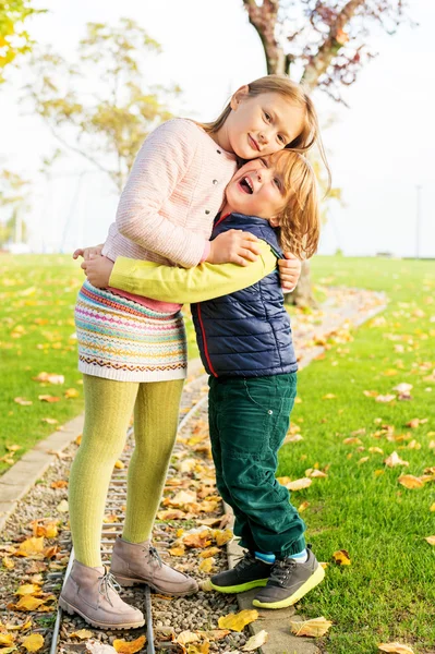 Duas crianças adoráveis brincando no parque em um belo dia de outono — Fotografia de Stock