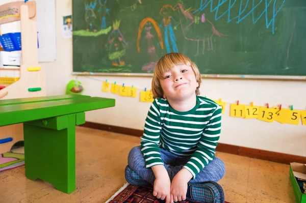 Indoor portrait of a cute little boy in a classroom — Stock Photo, Image