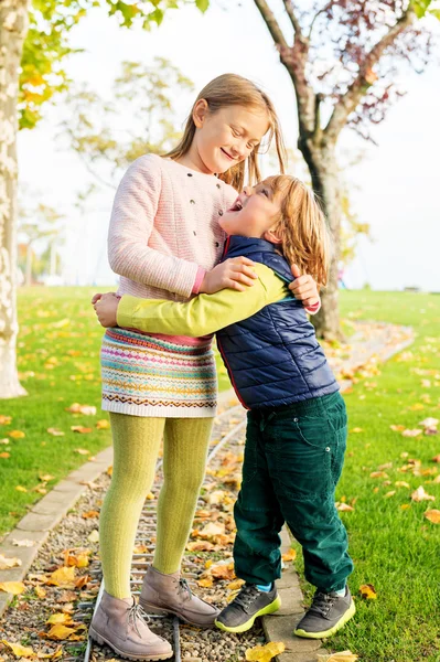 Two adorable kids playing in the park on a nice autumn day — Stock Photo, Image