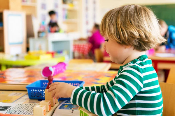 Indoor portrait of a cute little boy in a classroom — Stock Photo, Image