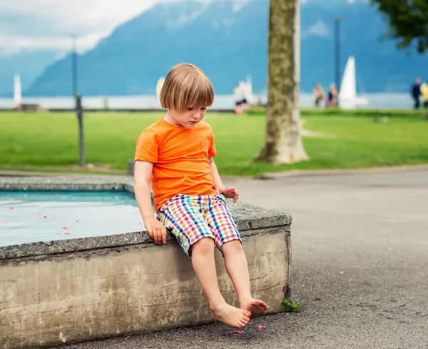 Netter kleiner Junge von 4-5 Jahren, der an einem schönen Sommertag im Brunnen spielt — Stockfoto