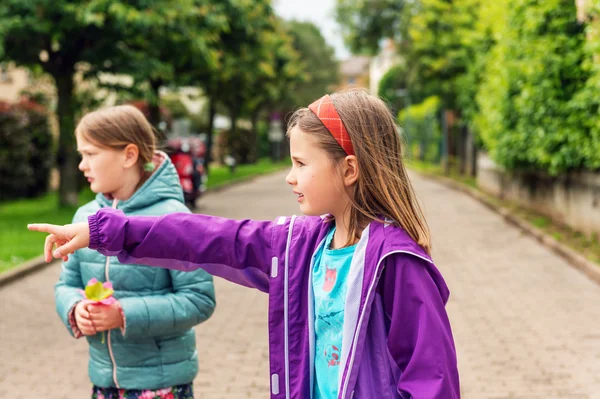 Two little girls playing outdoors, wearing jackets — Stock Photo, Image