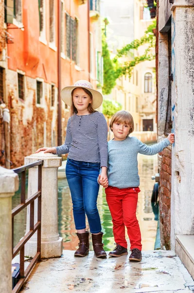 Открытый портрет восхитительных модных детей, посещающих Венецию, Италия. Девочка и мальчик ходят по старым венецианским улицам — стоковое фото