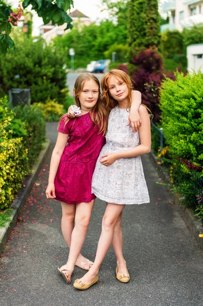 Внешний портрет очаровательных маленьких девочек, одетых в красивые платья — стоковое фото