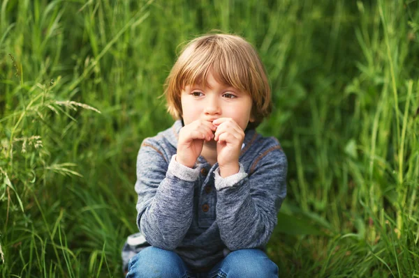 Retrato franco de adorable niño de 4-5 años, con capucha azul, jugando solo al aire libre — Foto de Stock