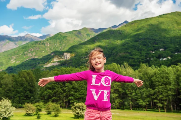 Милая маленькая девочка, путешествующая в швейцарских Альпах, широко раскрытые объятия. Фотография сделана на перевале Симплон, граница между Швейцарией и Италией — стоковое фото