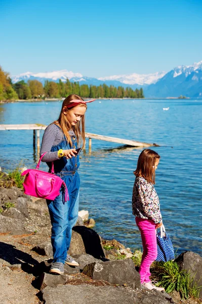 Deux adorables petites filles jouant au bord du lac par une belle journée ensoleillée d'été. Photo prise sur le lac Léman, Suisse — Photo