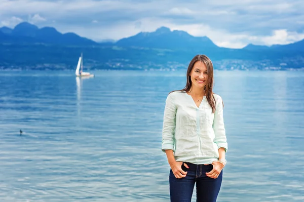 Porträt einer jungen brünetten Frau, die draußen am See posiert — Stockfoto