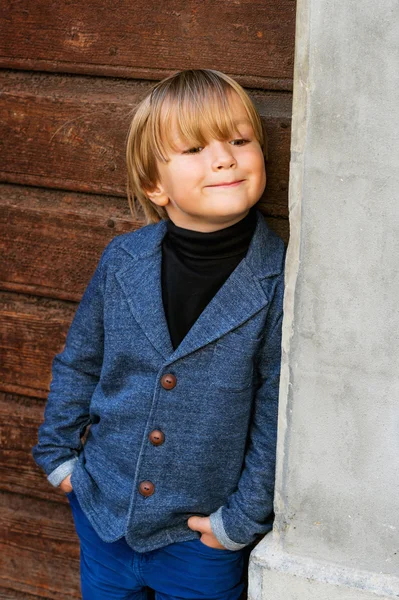 Retrato de moda de um menino loiro bonito, vestindo pescoço rolo preto e casaco azul — Fotografia de Stock